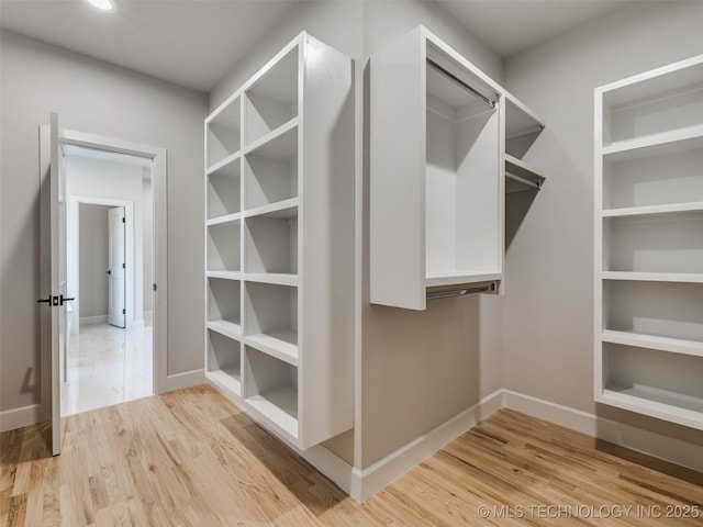 walk in closet with hardwood / wood-style flooring