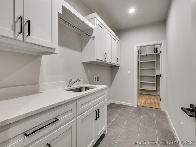 washroom featuring hookup for a washing machine, sink, and cabinets