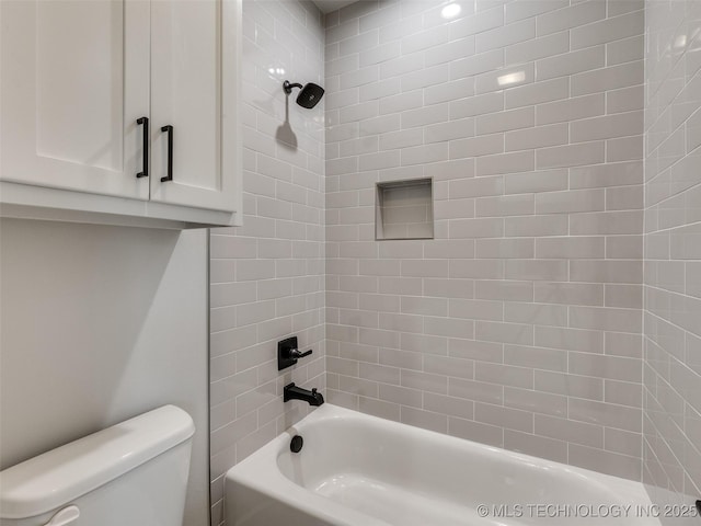 bathroom featuring tiled shower / bath and toilet