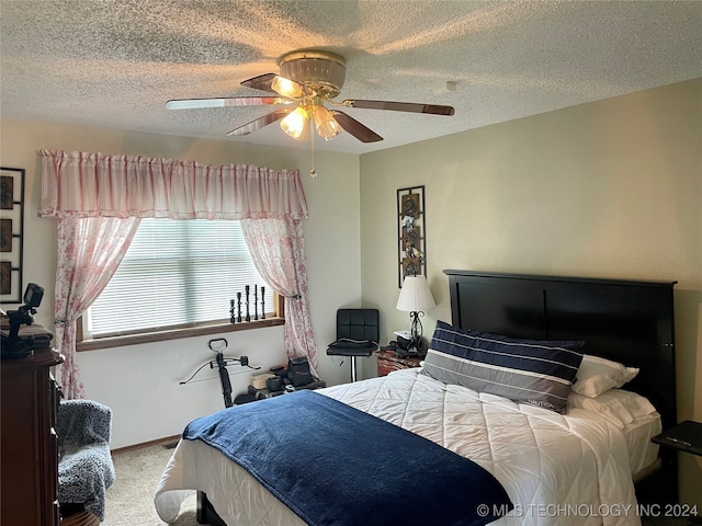 bedroom with a textured ceiling, ceiling fan, and carpet floors