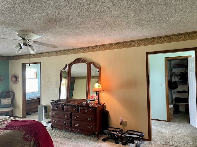 bedroom featuring radiator heating unit, a textured ceiling, ceiling fan, and carpet