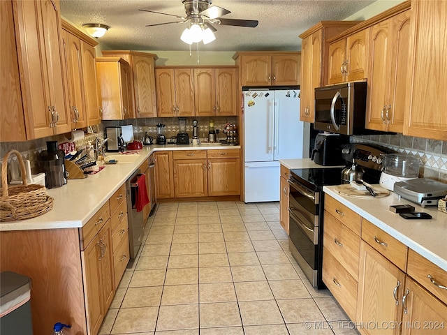 kitchen featuring appliances with stainless steel finishes, decorative backsplash, light tile patterned flooring, and ceiling fan