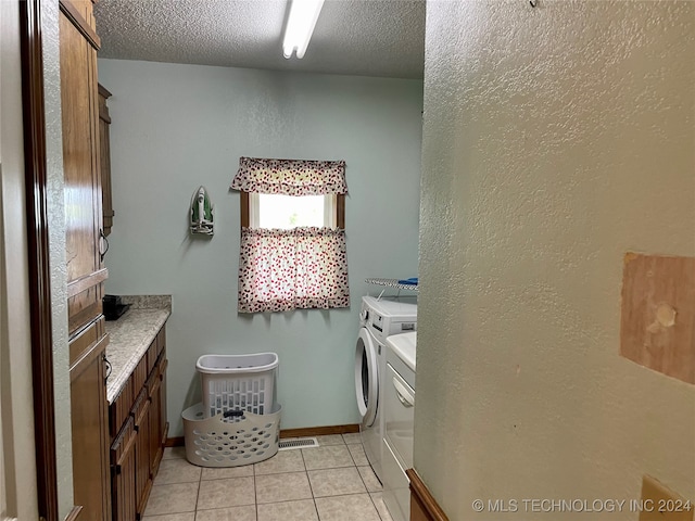 bathroom featuring tile patterned floors, a textured ceiling, and washing machine and dryer