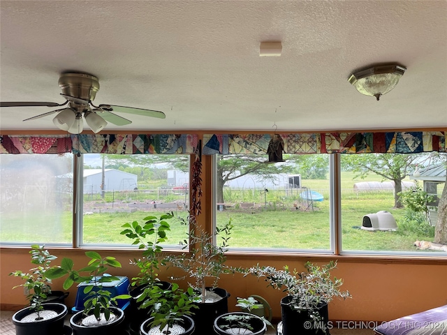 unfurnished sunroom with a healthy amount of sunlight and ceiling fan