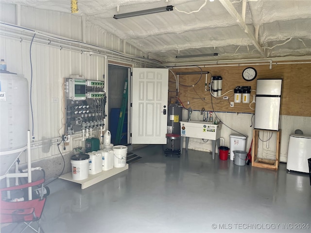 garage featuring electric water heater and sink