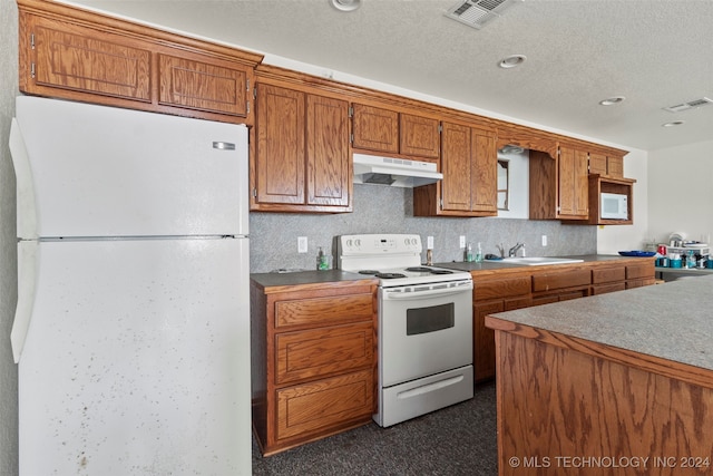 kitchen with a textured ceiling, sink, and white appliances