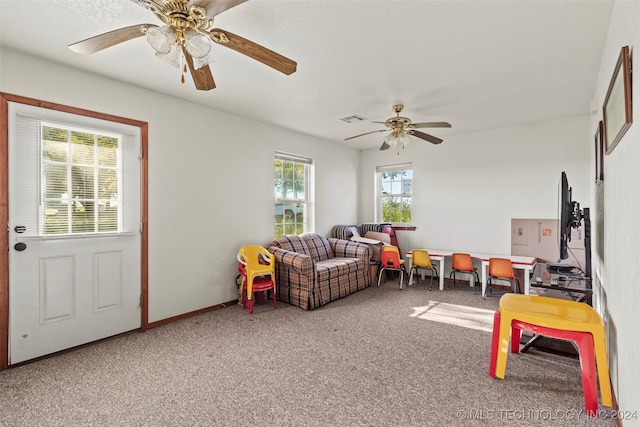 game room with a wealth of natural light, ceiling fan, and carpet flooring