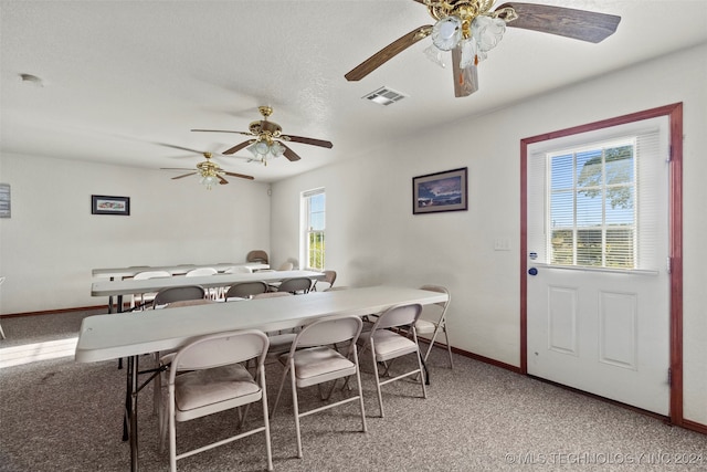 dining area with a textured ceiling, carpet flooring, and ceiling fan