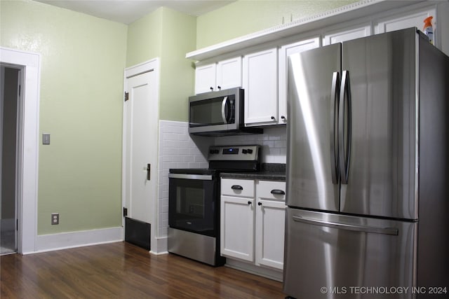 kitchen with tasteful backsplash, dark wood finished floors, dark countertops, stainless steel appliances, and white cabinetry