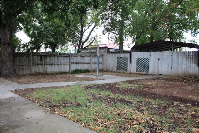 view of yard with fence and a detached carport