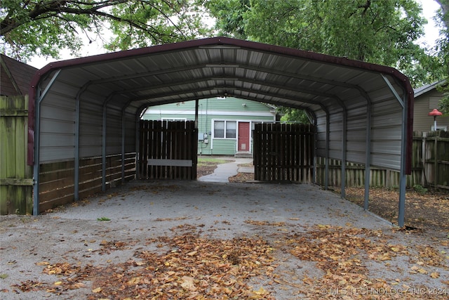 view of car parking with fence and a detached carport