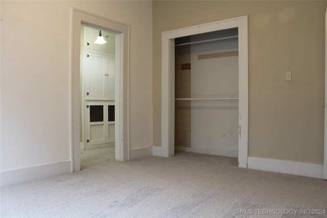 unfurnished bedroom with a closet, baseboards, and carpet flooring