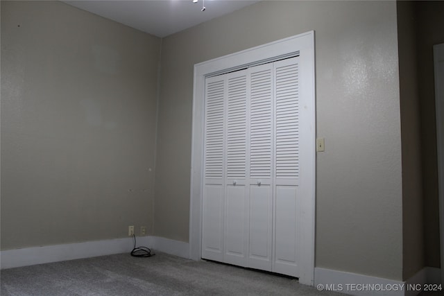 unfurnished bedroom with a closet and carpet flooring