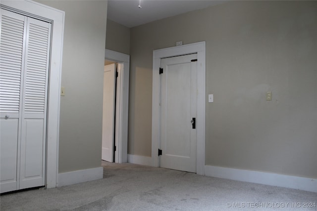 unfurnished bedroom featuring carpet floors, a closet, and baseboards