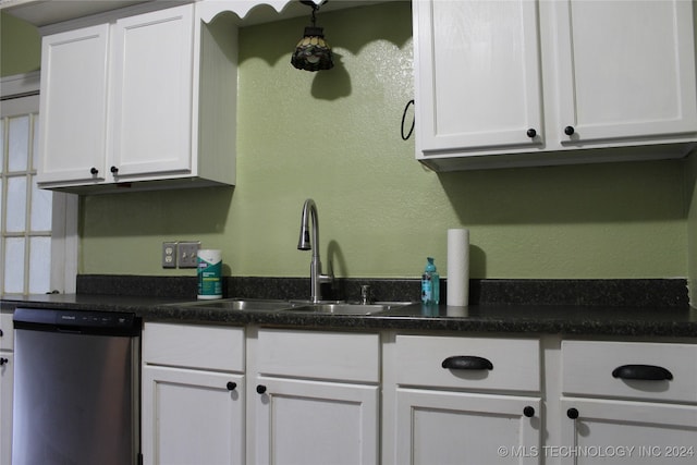 kitchen featuring a textured wall, white cabinetry, dishwasher, and a sink