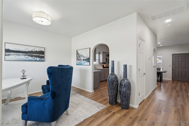 home office with hardwood / wood-style flooring and sink