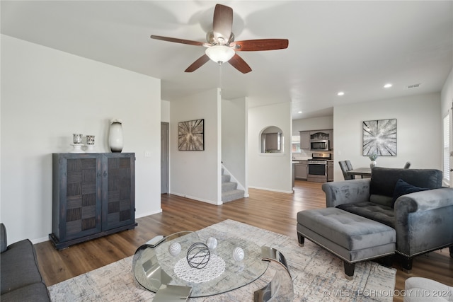 living room featuring hardwood / wood-style floors and ceiling fan