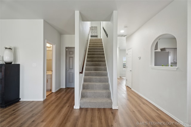 stairs featuring hardwood / wood-style floors