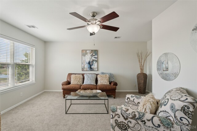 carpeted living room with ceiling fan