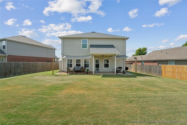 rear view of house with a yard and a patio