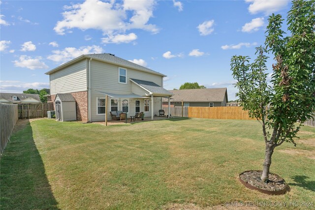 back of property with a yard and a storage unit