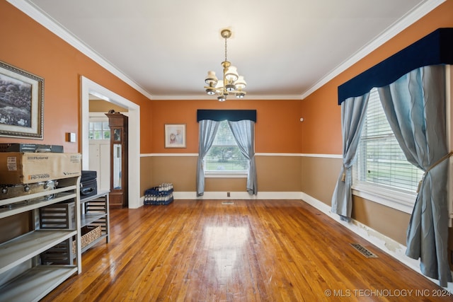 dining room featuring an inviting chandelier, ornamental molding, hardwood / wood-style floors, and a wealth of natural light