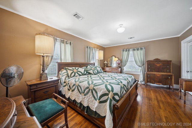 bedroom featuring multiple windows, dark wood-type flooring, and crown molding