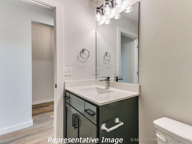 bathroom with vanity, toilet, and wood-type flooring