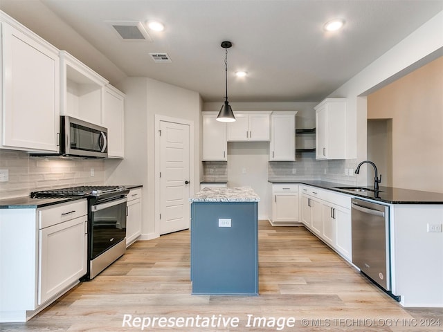 kitchen featuring stainless steel appliances, sink, white cabinets, and light hardwood / wood-style floors