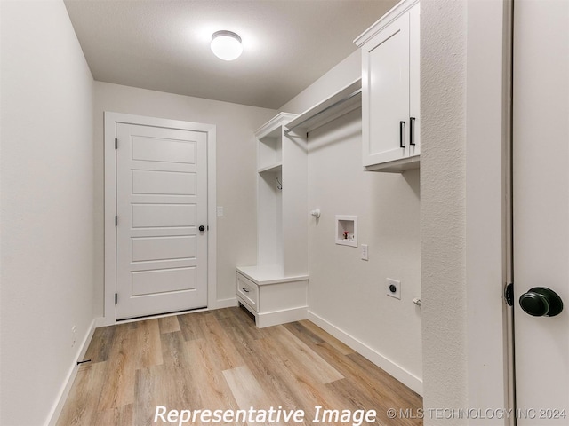 washroom with light wood-type flooring, hookup for a washing machine, hookup for an electric dryer, and cabinets