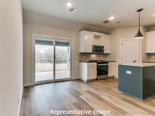 kitchen featuring decorative light fixtures, light hardwood / wood-style flooring, appliances with stainless steel finishes, decorative backsplash, and light stone counters