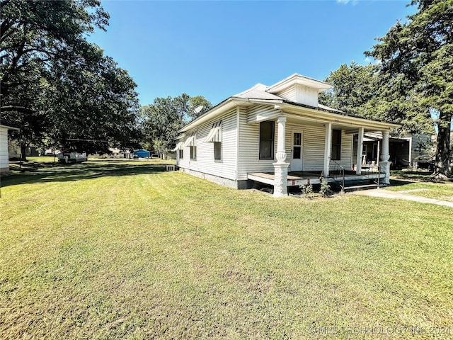 view of home's exterior with a yard and a porch