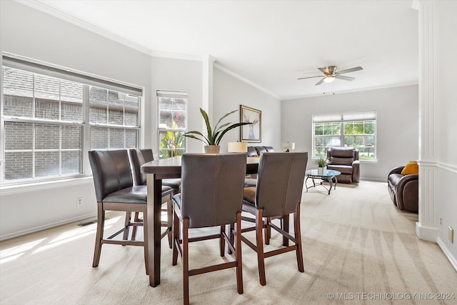 carpeted dining area featuring ceiling fan, ornate columns, and crown molding