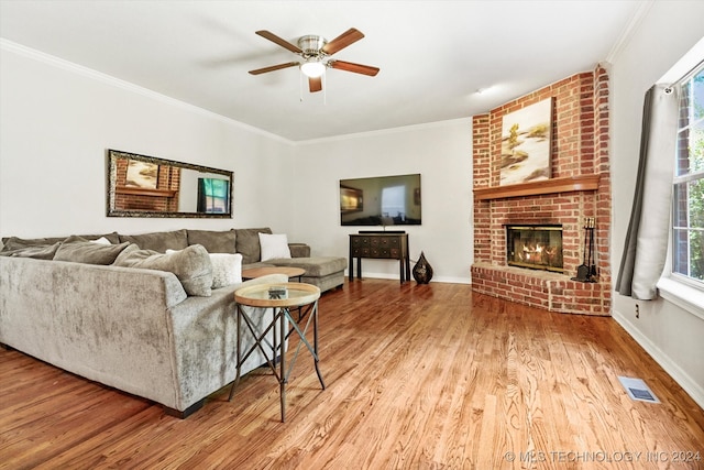 living room featuring a brick fireplace, crown molding, ceiling fan, and hardwood / wood-style flooring