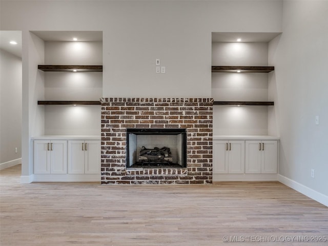 unfurnished living room with a fireplace and light hardwood / wood-style floors