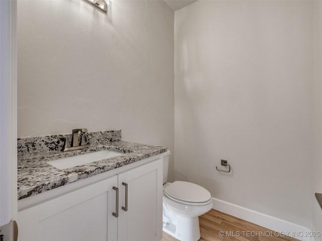 bathroom with vanity, toilet, and hardwood / wood-style floors