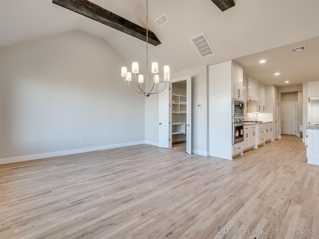 kitchen featuring stainless steel appliances, a notable chandelier, white cabinets, vaulted ceiling, and light wood-type flooring