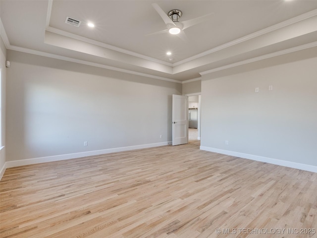 unfurnished room with crown molding, light hardwood / wood-style flooring, ceiling fan, and a tray ceiling