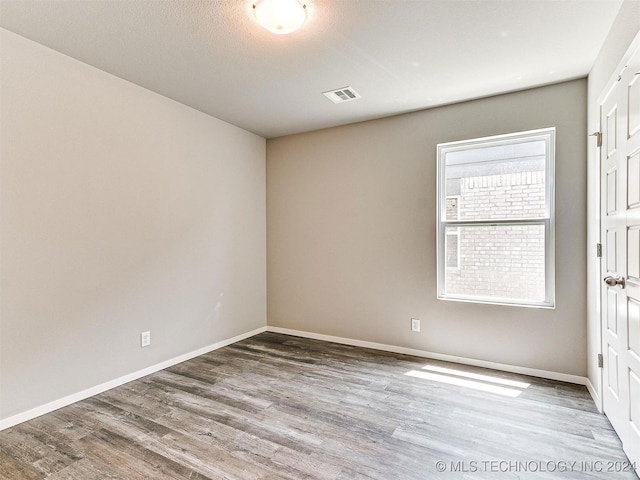 spare room with hardwood / wood-style flooring and a textured ceiling