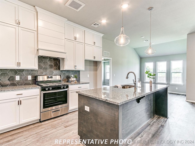 kitchen featuring gas range, an island with sink, sink, white cabinetry, and light wood-type flooring