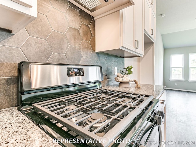 kitchen featuring white cabinets, custom exhaust hood, stainless steel gas range, dark hardwood / wood-style floors, and tasteful backsplash