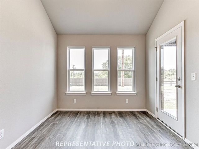 unfurnished room featuring lofted ceiling and dark hardwood / wood-style flooring