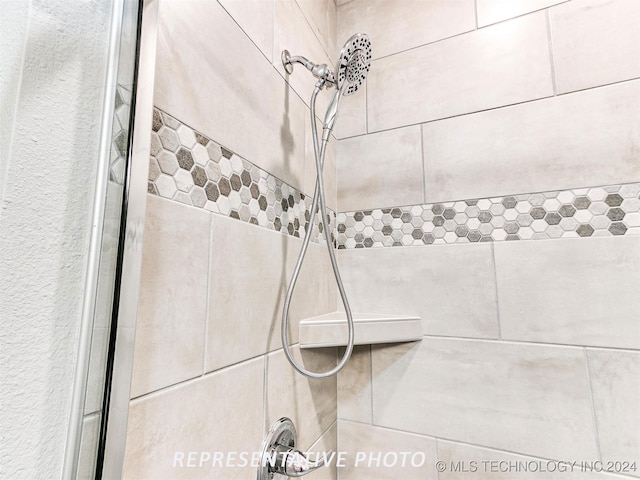 interior details featuring tiled shower