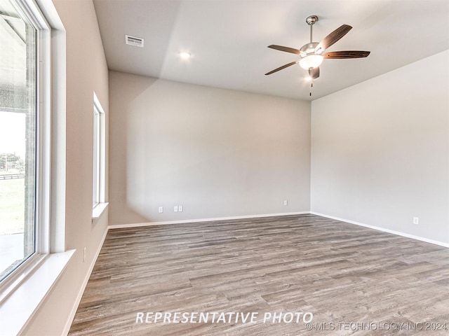 empty room with hardwood / wood-style flooring and ceiling fan