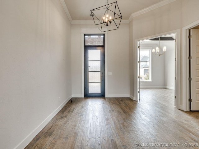 foyer entrance featuring hardwood / wood-style flooring, ornamental molding, and a chandelier