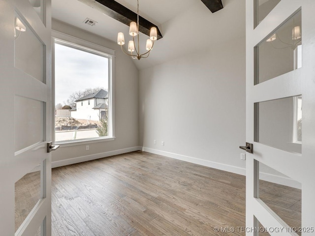 unfurnished room featuring a notable chandelier, wood-type flooring, and vaulted ceiling with beams