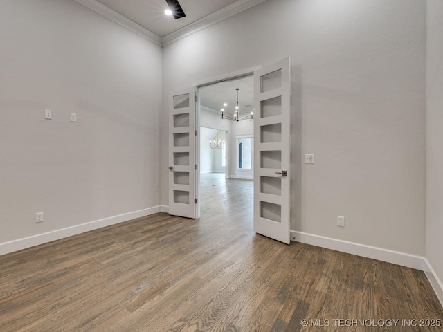 unfurnished room featuring crown molding, wood-type flooring, and a chandelier