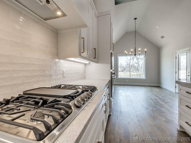 kitchen with dark wood-type flooring, white cabinetry, gas stovetop, decorative backsplash, and vaulted ceiling