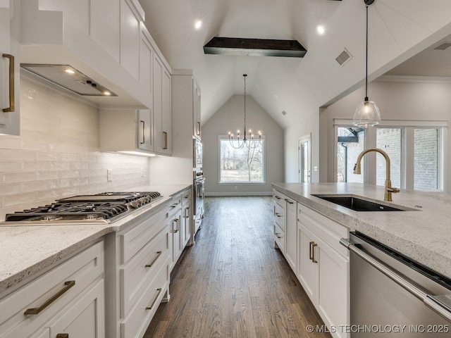 kitchen featuring light stone counters, sink, stainless steel appliances, and custom range hood