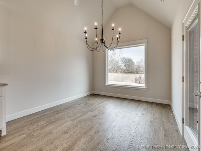 unfurnished dining area with lofted ceiling, light hardwood / wood-style flooring, and a chandelier